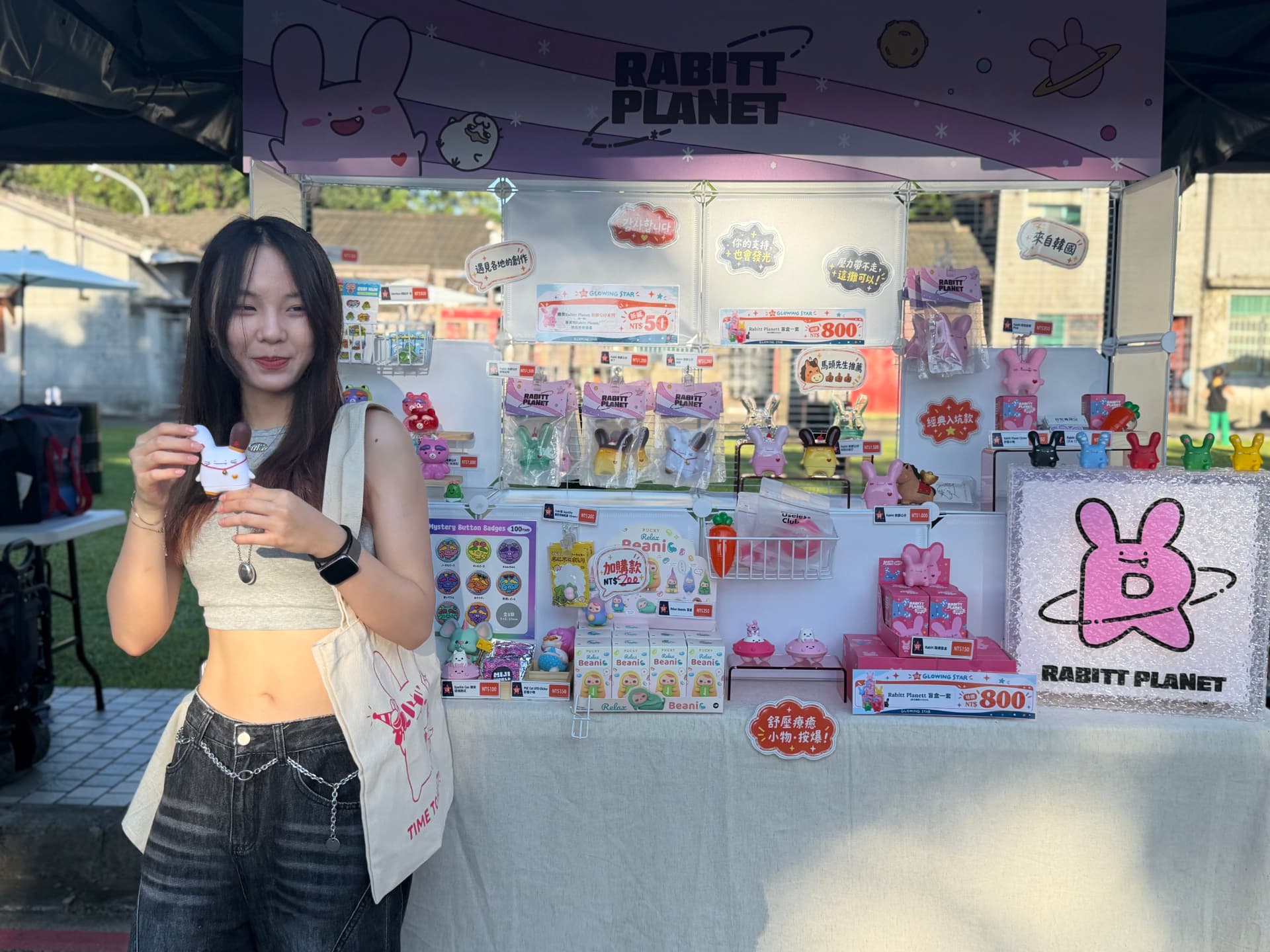 The Glowing Star booth at 眷村嘉年華, with the Rabitt Planet banner, product shelves and a visitor holding a figure